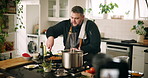 Camera, cooking and man in kitchen with dinner, meal or recipe online with content creation. Food, recording and male chef influencer with equipment for live streaming with diet advice in home.