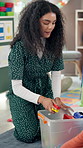 School, children and teacher with toys to pack, cleaning and conversation with students for learning. Kindergarten, kids and woman as educator for education game, creative activity and tidying class