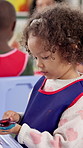 Girl, kid and painting on hand in classroom for creative learning, art project or motor skills development. Kindergarten, child student and messy color for artwork activity, education and exploration