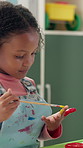 Girl, child and painting on hand at school for creative lesson, art project or motor skills development. Kindergarten, student or paintbrush for messy artwork, learning activity or education in class