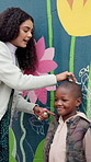 Teacher, student and kid by wall with chalk for height, measurement or drawing by mural outdoor. Recess, creative and line for growth, woman and boy by flower painting at art academy or preschool