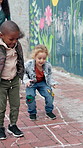 Children, teacher and jump for hopscotch outdoor, recess or playground with energy at kindergarten academy. Playful, fun and hopping or student growth, development or games in school courtyard