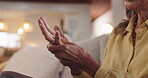 Hands, injury and massage with senior person on sofa in living room of home for recovery or relief. Arthritis, carpal tunnel and osteoporosis with old woman in apartment for inflammation or pain