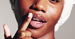 Woman, skincare and sugar scrub on lips for beauty treatment, shine or natural exfoliation. Closeup, mouth or happy model apply cosmetics on face for glow, peeling or clean on white studio background