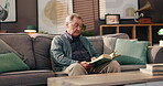 Sofa, senior man and relax with book for reading, knowledge and comfortable in retirement at home. House, male person and elder with novel for story, information and language learning on couch
