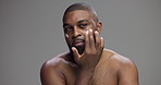 Face, skincare and black man apply cream for treatment, self care and dermatology. Moisturizer, product and person with beauty lotion for facial hydration, cosmetics or glow on gray studio background