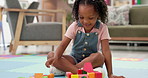 Building blocks, playing and child in living room in home for cognitive development or creativity. Learning, floor and girl kid with educational toys for fine motor skills or sensory in house.