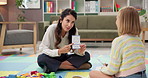 Psychologist, emotion test and child in therapy for learning, talk or help for development. Kid, woman and counseling session in office with card for feelings, cognitive behavior and cbt for sad mood