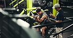 Men, workout or bicep curl with personal trainer at gym for strength training or arm exercise on machine. Male people, fitness instructor or coach with tablet for physical routine or health checklist