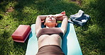 Yoga, above and woman in park relax after exercise, workout and training outdoor in morning. Nature, pilates and person resting, calm and breath on mat for wellness, health and zen energy on grass