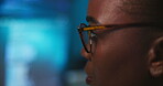 Online, hacker and woman with glasses, night and programming of cybercrime, serious and fraud in office. Coding, criminal and black person with eyewear for phishing, system and reading info for scam