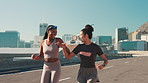 Outdoor, friends and running with fist bump for fitness, motivation and partnership for training in city. Road, people and women with hand gesture for exercise growth, workout challenge and happiness