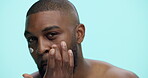 Cream, smile and skincare with face of black man in studio for cosmetics, dermatology or self care. Lotion, beauty and male grooming with person on blue background for hydration, collagen and facial