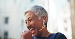Woman, laugh and dance with earphones in city for listening to music, streaming audio and travel fun. Excited, mature person and moving for groove playlist, morning commute and celebration of journey