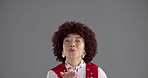 Blowing kiss, smile and face of woman in studio with peace sign, laughing and happy. Confidence, mockup space and portrait of person with love emoji, hand gesture and flirting on gray background