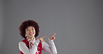 Pointing, mockup and face of woman in studio for marketing, announcement or choice by space. Excited, presentation and portrait of female person with decision for advertising by gray background