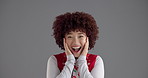 Face, reaction and surprise with woman in studio for expression, good news or gossip. Emoji, energy and wow with happy person isolated on gray background for announcement, information or promotion