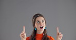 Pointing, shock and woman in studio for marketing, announcement or choice by mockup space. Surprise, presentation and female person with decision for advertising or promotion by gray background.
