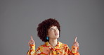 Woman, pointing up or studio with mockup for advertising or marketing on a gray background. Female person, afro or model with space or select for notification, alert or looking at list, tip or choice