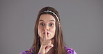Studio, face and woman with secret, silence and privacy for drama, mockup space and confidential news. Gray background, expression and person with finger on mouth, hush and gesture for mystery in USA