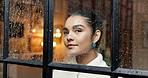 Woman, thinking and looking out window with rain drops for winter season, cold weather or outdoor dream at home. Female person, relax and wonder with thought for condensation or reflection at house