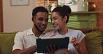 Couple, relax and laughing with tablet on sofa for playing funny game, watching comedy video and bonding. Interracial people, happy and digital app in home for streaming service, movie date and love