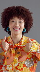 Woman, face and fashion in studio with thumbs up, happy or approval emoji with confidence. Girl, retro style or laugh on gray background with yes reaction, like icon or gesture for support in Brazil