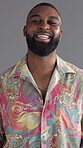 Laughing, groovy and fashion with face of black man in studio for retro style, funky and bohemian culture. Paisley shirt, indie aesthetic and disco with person on gray background for funny and comedy