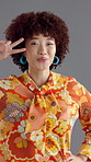Face, dancing and woman with retro clothes, peace sign or confident personality on gray background. Happy person, fashion or vintage outfit with stylish wardrobe, colourful or smile with pride or joy