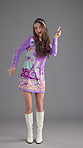 Face, dancing and woman with fashion, vintage clothes and colourful dress on gray background. Happy person, model and retro outfit with movement, stylish wardrobe and smile with pride and confidence
