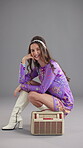 Smile, radio and fashion with face of woman in studio for retro style, funky vibe and bohemian culture. Groovy streaming, indie aesthetic and disco music with person on gray background for sound