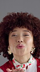 Face, woman and blowing kiss for fashion, retro apparel with flirting and confidence on gray background. Happy, portrait and African person with afro, vintage style or lips with gesture in studio