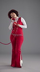 Girl, happy and retro telephone in studio with chat for story, gossip and disco style by background. Woman, phone call and smile for discussion, contact and laugh at comic joke with vintage fashion