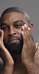 Face, skincare and man with cosmetics, studio and self care with facial treatment and moisturizing. Gray background, healthy and black person with routine for glow, dermatology or grooming in morning