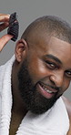 Brushing, hair and man with smile, face or tool for grooming in morning, studio or confident with routine. Gray background, haircare and black person with pride for haircut, styling or happy in Kenya