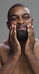 Studio, smile and man with routine for skincare, moisturizing and facial treatment for glow in morning. Gray background, happy and black person with cosmetics, self care and dermatology for face