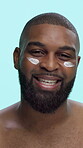 Black man, happy and cream on face in studio for skincare, cosmetics or moisturizer on blue background. Smile, portrait and male person with lotion, sunscreen or facial treatment for dermatology