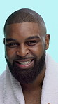 Face, towel and black man in studio for skincare, beard or grooming with hygiene, treatment or natural cosmetics. Beauty, happy or model laughing with facial hair or dermatology on blue background