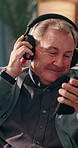 Phone, headphones and senior man home for streaming service, music and jazz playlist for freedom. Mobile, dance and happy person moving to audio and listening to radio on internet in retirement