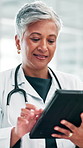 Doctor, smile and mature woman with tablet for healthcare report, telehealth and schedule in hospital. Technology, medical professional and reading research, wellness app and scroll email in clinic