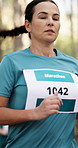 Marathon, woman and running a race in forest for fitness challenge, sports event or endurance. Runner, mature person or cardio exercise in nature for competition performance, outdoor training or pace