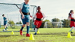 Kids, running and cones for soccer practice with resistance, strength training and fitness exercise. Children, equipment and sports workout for endurance, drill challenge and team for cardio routine
