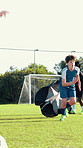 Field, boy and football player with parachute for training, strength practice or running with endurance. Pitch, male person or child with equipment for wellness, sports exercise or fitness for soccer