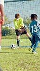 Boys, kids or soccer player with skill or goal for win at game or match in youth tournament. Sports, nutmeg or back of football athlete shooting ball in net at target practice on field at stadium