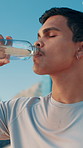 Drinking water, break and man for fitness, training and runner health for cardio or marathon in city. Hydration, athlete and challenge with energy in street for sports exercise, workout and wellness