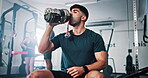 Athlete, man and drink water in gym for fitness, hydration and thirsty from workout routine. Active male, bottle and refreshing liquid for training recovery, exercise performance and wellness goals