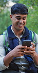 Phone, nature and man hiking in forest with laugh, social media and mobile app meme or joke. Smile, technology and male person typing on cellphone trekking in outdoor woods for exploring or adventure