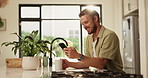 Coffee, phone and man in kitchen in home for networking, connectivity or social media scrolling. Morning, technology and male person with cappuccino and browsing on mobile app with cellphone in house