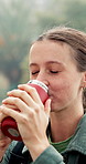 Flusk, hiking and woman in forest, coffee and morning with environment, caffeine and health. Person, outdoor and hiker in woods, tea or countryside with wellness, winter or wilderness with trekking