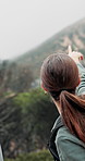 Woman, back and hiking with bag in forest for outdoor adventure, journey or trip in nature. Female person, pointing or hiker walking with backpack for sightseeing, direction or trekking in woods